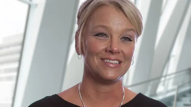 Bankers Insurance Customer Success Woman dressed in business casual attire smiling and looking forward.