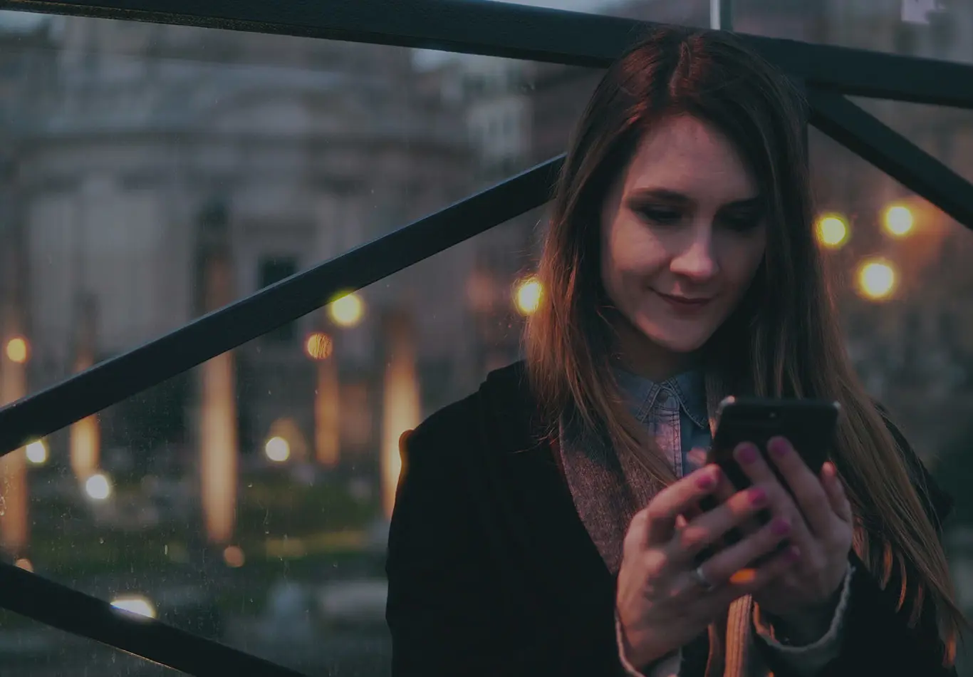 Rating Services Key Benefit 2 A business woman is looking at her phone outside